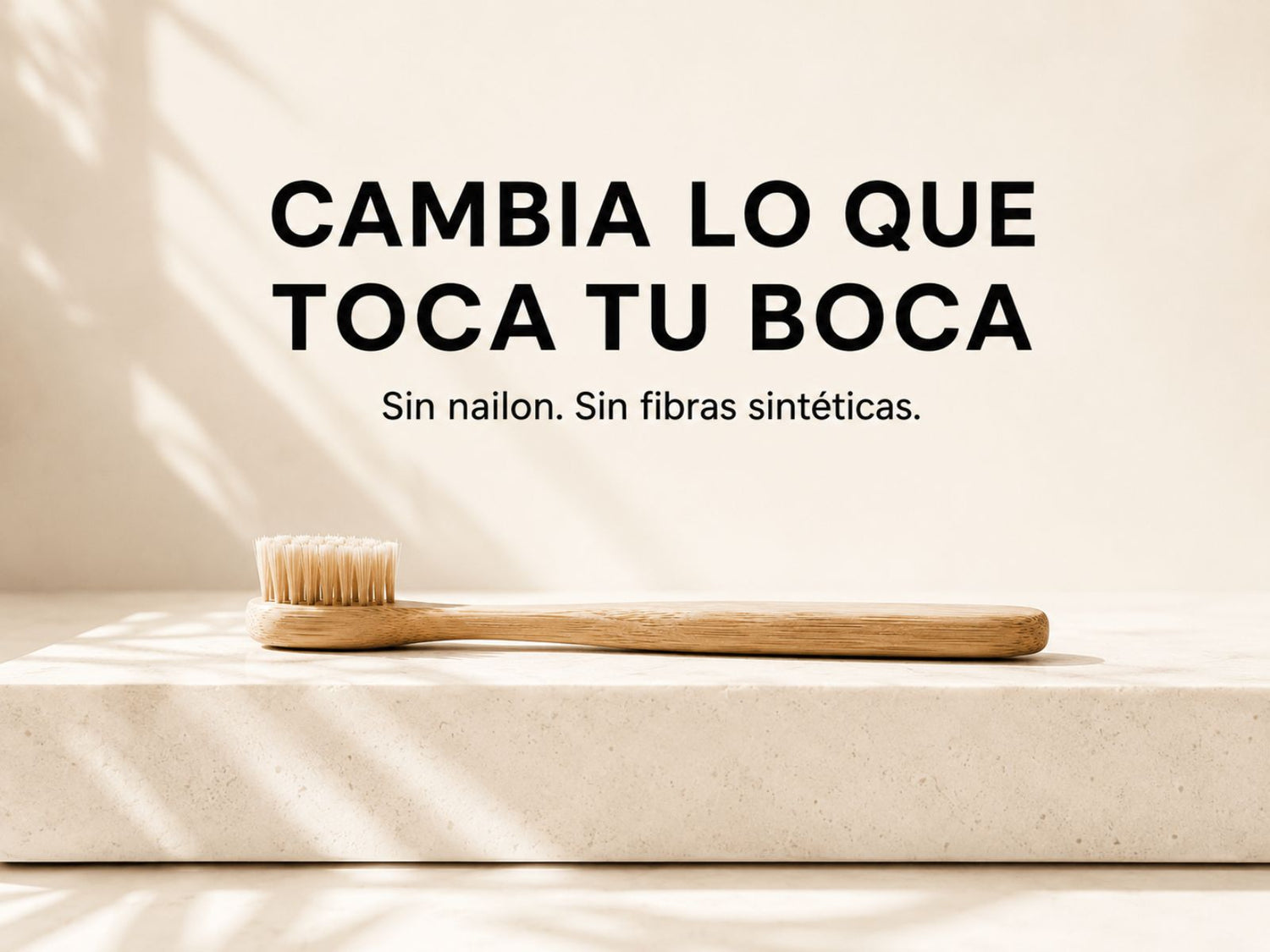 Cepillo de dientes de bambú con cerdas naturales sobre una superficie minimalista de baño.