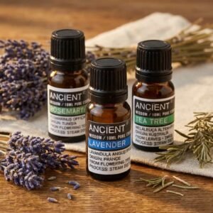 Pack de aceites esenciales con lavanda, romero y árbol de té en frascos de vidrio ámbar sobre fondo natural con flores y hierbas secas